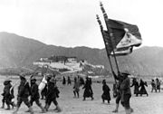 1938年新年在布達拉宮前接受校閱的藏軍官兵。右上可見雪山獅子旗