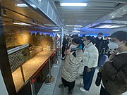 游客驻足观赏换乘通道中展示的6号线建设过程中挖掘发现的古井（2023年2月）