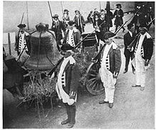 大鐘被懸於馬車上。穿著美國革命戰爭軍服的士兵在邊上待命。