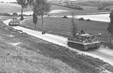 四辆坦克通过乡间林林荫道.