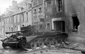 一辆陷在砾石中的坦克位于一处烧毁的房舍前,它跨在马路与人行道上.