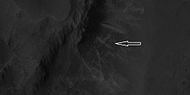 上一幅高分辨率成像科学设备图像中的脊线近景图，箭头指示了一处“X”形脊线。