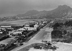 位于启德机场东侧的启德皇家空军基地。英军在1920年代已计划在香港派驻空军，但受到《华盛顿条约》的限制，所以先由港府兴建民用的启德机场，机场于1929年启用，再在机场东侧增设空军基地，成为军民两用的机场，而机场跑道也是军民共用。本图约摄于1945年8月日本投降后，图中左下角停泊有盟军车辆，图中央的道路是后来的观塘道。