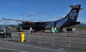 一架新西兰航空的ATR 72-600飞机。飞机涂装为全黑色，尾翼的航空公司标志源于被毛利人称为“科鲁”的银叶蕨卷曲的嫩蕾，机身也绘有银叶蕨图案。